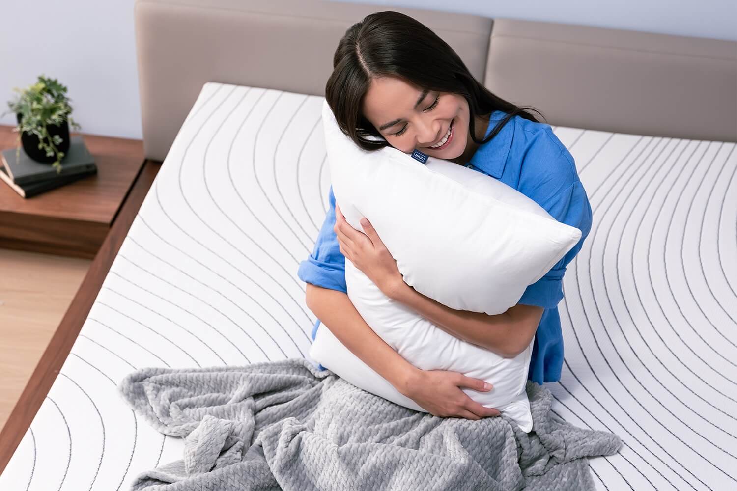 Woman sleeping peacefully on her back with her head on the Octave Down Alternative Pillow.