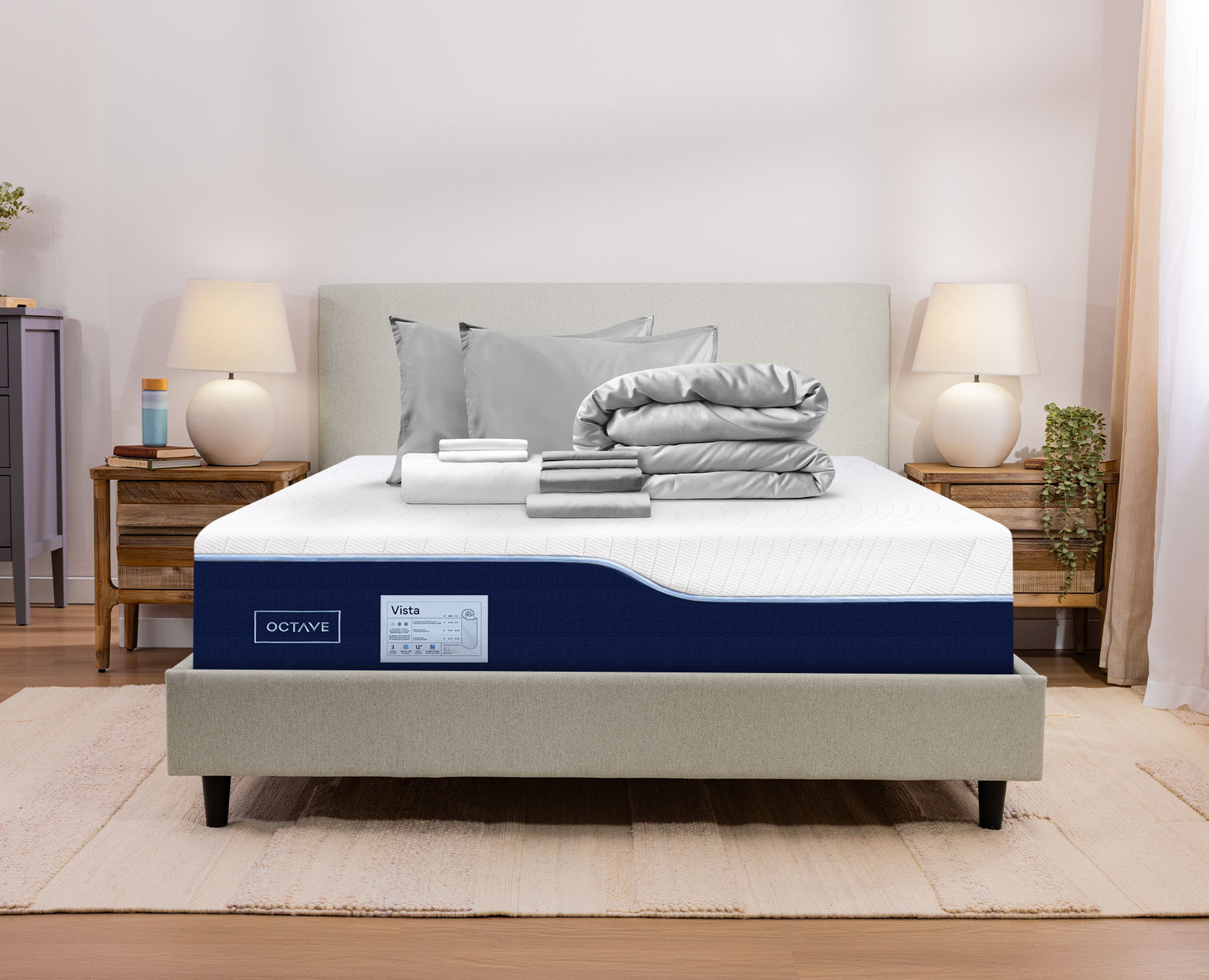 A grey premium sleep bundle sits neatly folded on an Octave Vista Mattress