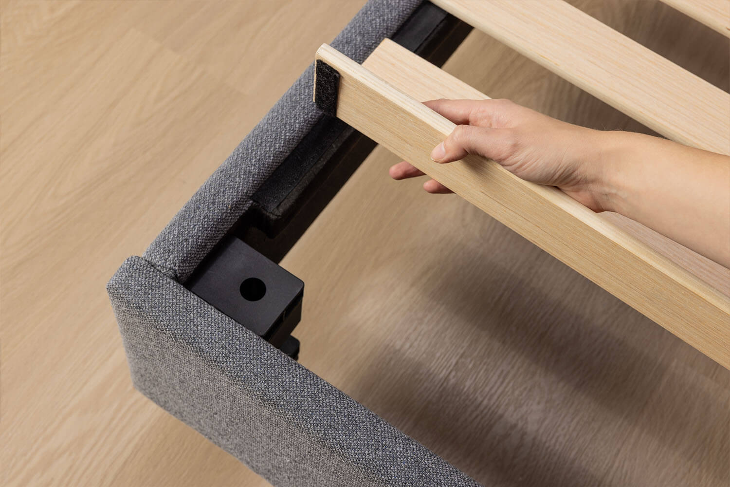 Close up of a person installing the wood slats with Velcro on the Platform Bed.