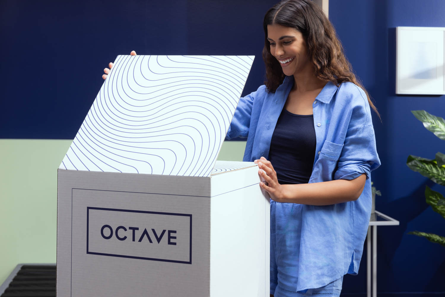 Woman smiling and unboxing Octave mattress