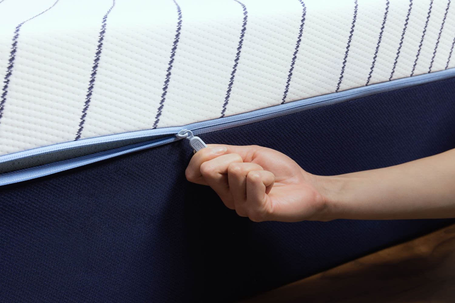 Woman unzipping the cover on the Octave Horizon mattress